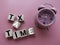 concept image alarm clock and wooden block word - TAX TIME on pink background