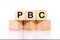 Concept image of Business Acronym PBC as Performance Based Contract written on wooden cubes on a white background