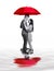 Concept image of couple in love standing under large red umbrella  and reflections in puddles.  Isolated on White.