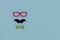 Concept image with glasses, moustache and bow tie on light blue background as resource for creative projects, copy space on the