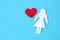 Concept image of a heart shape and a woman figure on a textured blue background.