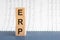 Concept image a wooden block and word ERP - Enterprise Resource Planning - with shadow selective focus a row of blocks is located