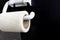 The concept of inadequate savings. Mesh fiber hangs on toilet paper holder on black background. Irrational thinking as Plan B or