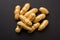 Concept of individuality, luck,value,exclusivity and better choice. Golden peanut or ground nut, standing out amongst normal peanu