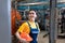 The concept of industrial manufactory. Portrait of a young smiling woman in uniform holds a safety helmet in her hand. Boiler room