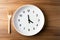 Concept of intermittent fasting, showing an empty plate and a clock. The practice of eating within specific time. AI