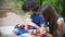 Concept of internet addiction, teen boy and girl use their smartphones, sitting hunched on a bench in the park on a