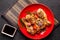 The concept of Japanese and Chinese cuisine. Chicken fried legs with hot pepper, sesame, chuka salad, Chinese peas on black table