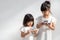 Concept kids and gadgets. Two little girls siblings sisters look at the phone. They hold a smartphone watch videos, learn, play