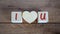 Concept letters I and U made on wooden blocks. Wooden heart