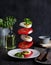 Concept levitation food. Italian caprese salad with tomatoes, mozzarella cheese, basil and pesto sauce fly over the plate on a