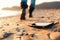 The concept of losing your phone. The smartphone lies on the sand, on the beach. In the background, blurred removing footsteps of