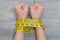 Concept of lossing weight. Woman`s hands tied with yellow tape m