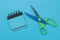 The concept of minimalism. Blue and green scissors and a blue notebook on a bright blue background. top view