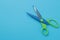 The concept of minimalism. Blue and green scissors on a bright blue background. top view. place for text