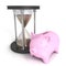 Concept money time piggy bank sand hourglass on white background