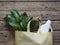 The concept of a natural eco-friendly laundry detergent for the bathroom. Green leaves of a tropical plant in a yellow cotton bag