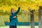 The concept of new opportunities. A young woman in a blue coat reaches for a tree to pluck a leaf. Close up