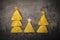 Concept of new year from mexican nachos. Christmas trees made of chips nachos with cheese on a dark background.