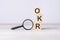 concept Objectives and Key Results or OKR. text on wooden cubes under a magnifying glass.