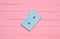 The concept of obsolete audio technology. Retro audio cassette on a pink pastel wooden background. Trend of minimalism.