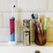 concept of oral hygiene of a large family. many different toothbrushes on the background of the faucet and the sink