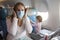 Concept panic coronavirus covid-19..a young mother is sitting in an airplane chair in a medical respiratory mask with a
