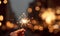 Concept of party nightlife and new year eve. Close up of hand with fire sparkler to celebrate the night and the new