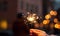 Concept of party nightlife and new year eve. Close up of hand with fire sparkler to celebrate the night and the new