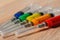 Concept photo of the COVID virus vaccine search. Syringes with different color filling