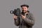 Concept - please smile. Emotional cameraman with retro camera in his hands, studio shot. Old-fashioned clothing style. Movie of