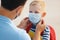 Concept of preventing a coronavirus covid-19 and viral infections. Father puts on medical mask for little son before school