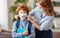 Concept of preventing a coronavirus covid-19 and viral infections. Mother puts on medical mask with painted smile for   son before
