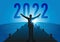 Concept of a rebirth of the economy, with an optimistic man opening his arms to welcome the year 2022.