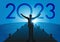 Concept of a rebirth of the economy, with an optimistic man opening his arms to welcome the year 2023.