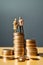 concept of retirement planning. Miniature elderly couple figure on a stack of coins