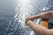 The concept of sea cruises. Men`s hands on the railing of the cruise ship on the background of the sea waves and sunset