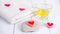 The concept of a Spa on Valentine`s Day. Red heart-shaped candles, stones, massage oil and a white towel on a wooden