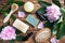 Concept SPA and Wellness. Massage brush, cosmetic oils and soap. Wooden background with peony flowers.