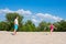 Concept about sports and active games in summer. Father and daughter play badminton on the beach on a summer sunny day