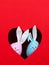 The concept of spring, happy Easter, eared pink and blue rabbit handmade, peek out of a hole in the shape of a heart on a red