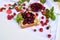 Concept of summer preparation of raspberry jam in a glass vase close-up on a light background with fresh raspberries and a piece o