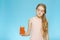 The concept is tasteless. The emotions of a child. The girl is grimaced and does not want to drink carrot juice.