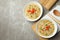 Concept of tasty eating with bowls of noodles on gray background