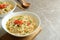 Concept of tasty eating with bowls of noodles on gray background