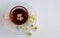 The concept of tea. A glass Cup on a saucer with flower tea and white flowers stands on a white background. Space for your text