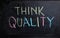 Concept always think of Quality. Handwriting text writing Think Quality on blackboard