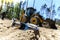 Concept of the tractor, the tractor digs and buries a trench for laying water on a forest plot for the construction of the house.