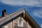 The concept of travel in Russia. Corner of roof of old wooden house with patterns on edges against blue sky. One of most