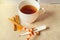 Concept of treating colds - hot tea with cinnamon, thermometer and scarf